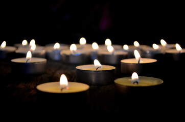 Many small christmas candles burning at dark. Shallow depth of field, selective focus