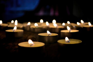 Many small christmas candles burning at dark. Shallow depth of field, selective focus