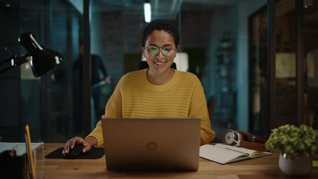 Zoom In Portrait of Young Hispanic Marketing Specialist Working on Laptop Computer in Busy Creative Office Environment. Beautiful Diverse Multiethnic Female Project Manager is Browsing Internet.