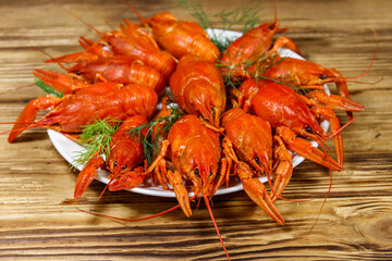Boiled crayfish in plate on wooden table
