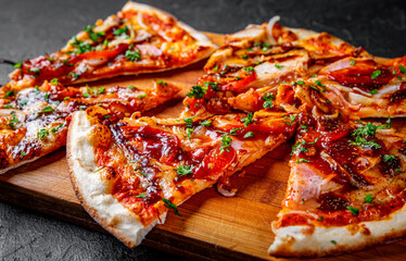 slice of Pizza with chicken and barbeque sauce. Italian pizza on Dark grey black slate background