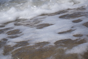 a foam wave of the north sea breaking on the beach

