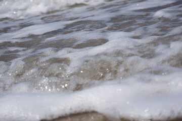 Obraz na płótnie Canvas a foam wave of the north sea breaking on the beach 