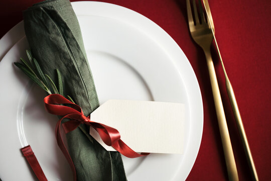 Close up view on setting plate with tag and golden cutlery. Christmas and Valentine table setting top view.