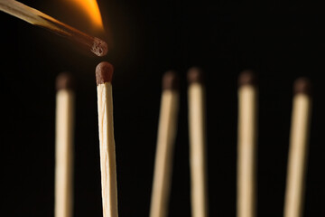 wooden lighted matches, standing on a black background