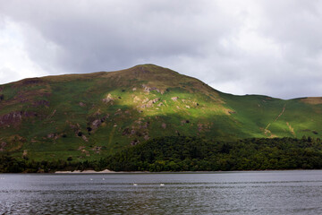 View of sea against mountain against cloudy sky