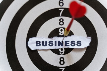 A piece of paper with the text is nailed to the target with a dart - BUSINESS
