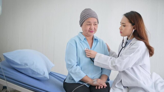 Cancer patient woman wearing head scarf after chemotherapy consulting and visiting doctor in hospital.