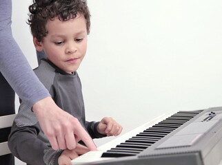 boy playing the piano keyboard on white background stock photo