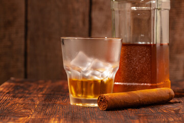 One glass of whisky and cigar on wooden table
