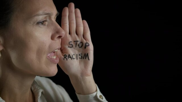Woman and racism move. A woman protest afainst racism on the black background.