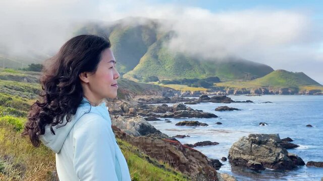 Asian woman hiking on one of the may trails in Big Sur on the Pacific Coast of California
