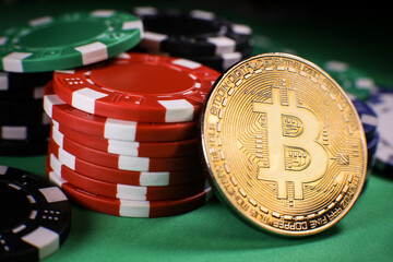 Bitcoin gold coin with poker chips on a green poker table against black background. Blockchain casino. Online gambling. 