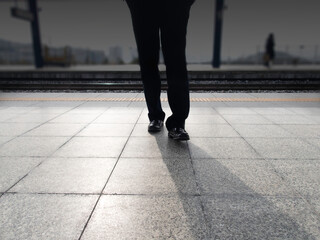 hombre de negocios esperando llegada del tren en el andén de la estación