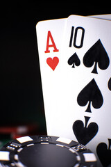 Poker playing chips with playing cards close up against the back background. . Online gambling. Addiction. Falling playing cards and poker chips