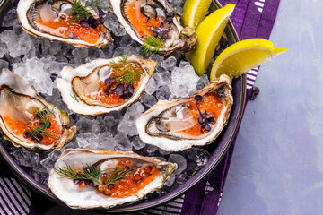 Tasty oysters on ice with lemon.
Refined with herbs and salmon caviar.