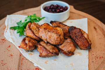 Delicious fried pieces of meat lie on a flatbread with parsley and sauce.