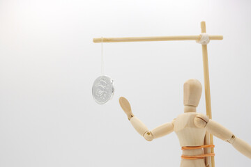 ぶら下げられた小銭を追いかけるデッサン人形
