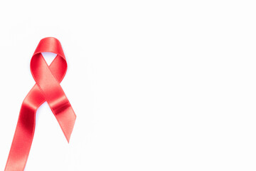 Aid ribbon silk. Red ribbon symbol in hiv world day isolated on white background. Awareness aids and cancer. Flat lay, top view, copy space