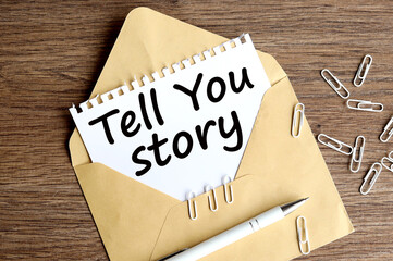 TELL YOU STORY. text on white paper on craft envelope on wood background