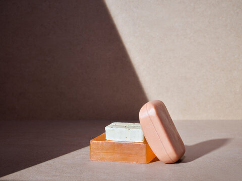 empilement de savons artisanaux pour le corps ou les mains, soins d'hygi&egrave;ne &eacute;cologiques sur un fond neutre baign&eacute; de soleil