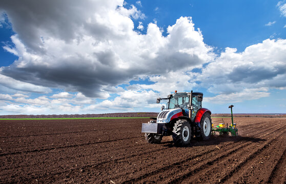 Varna, Bulagria - April 01, 2017. Big Steyr tractor with attached Great Plains seeder for sunflower seeds. Agriculture tractor sowing seeds and cultivating field.