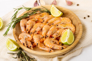 Shrimps on white dish over wood table