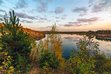 Naklejka na ściany i meble Autumn landscape with lake and clouds at sunset.