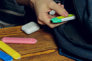 POD e-cigarette or nicotine vapor stick a by school bag.