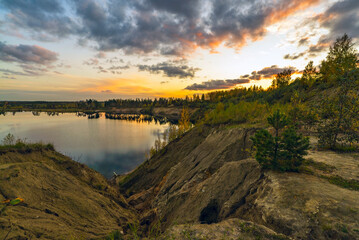Autumn landscape with beautiful clouds over the lake at sunset.