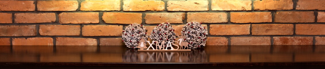 Xmas inscription and Christmas decorations on the background of an old brick wall.

