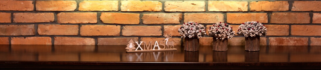 Fototapeta premium Xmas inscription and Christmas decorations on the background of an old brick wall.