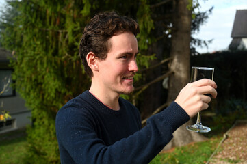Young man drinking a glass of wine outdoors