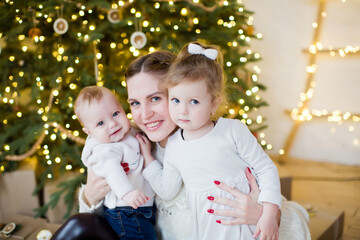 Fototapeta na wymiar Mother, son, daughter near Christmas tree
