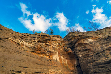 Sandy cliff view from the bottom up and blue sky.