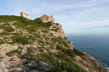 Fototapeta na wymiar Ruin buildings in Cape Espichel landscape with atlantic ocean and cliffs, in Portugal