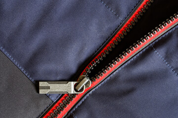 Metallic zip lock on a warm winter jacket made of polyester and water-repellent membrane. Blue,...