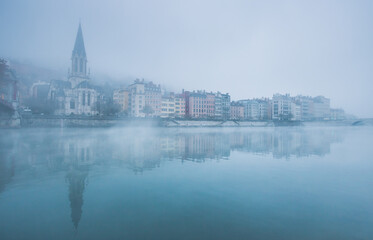 Fototapeta na wymiar Lyon sous la brume d'un matin automnal, l'église Saint-Georges et sa passerelle
