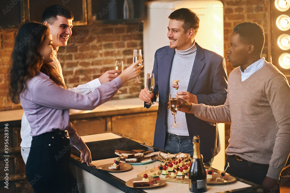 Wall mural pretty lady clinking glasses with friends during birthday party