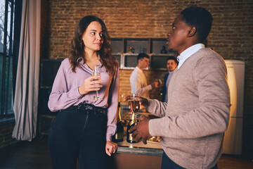 Two friends standing and talking during a party with friends