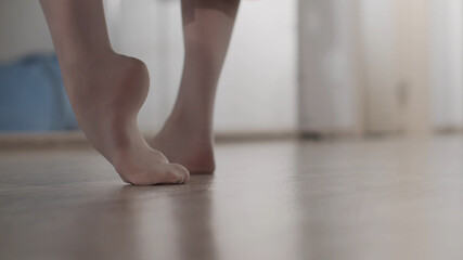 Feet of a girl dancer close-up at the warm-up before the performance, she kneads the muscles and joints