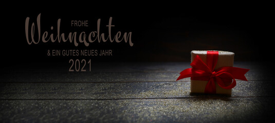 Christmas New Year greeting card 2021 with text in German - Frohe Weihnachten und ein gutes neues Jahr 2021 -Christmas present with red bow