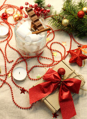 Christmas flat lei with a gift and a cup of marshmallows with chocolate and cinnamon