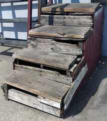Makeshift repairs on old weathered wooden steps.