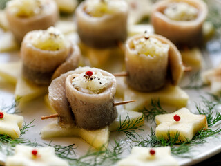 Herring fillets stuffed with chopped onions served on star-shaped apple slices close-up view. Traditional dish on the Polish Christmas Eve 