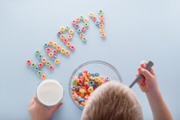 The child eating a breakfast cereal. word with grain loops happy on a blue background.top view