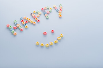 Word happy with grain loops and smiley on a blue background.top view