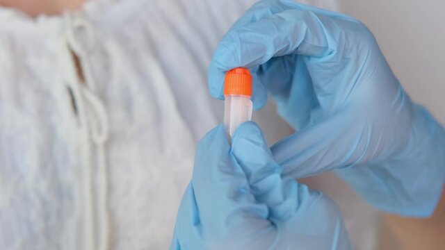 girl holds a kit for a dna test in a box, a cotton swab for scraping the epithelium, collecting genetic sample for analysis, concept of determining ethnic origin, paternity, genealogy, family tree