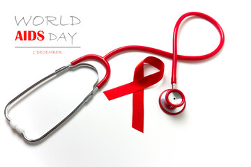 Inspirational text of World AIDS Day with red ribbon and stethoscope on a white background. AIDS disease awareness. Flat lay.