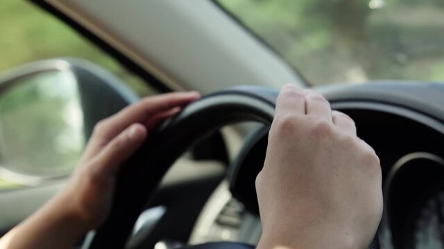 woman in a modern car listening music hitting the steering wheel